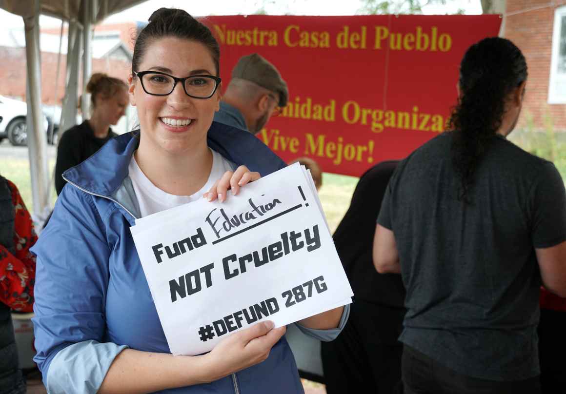 RISE Coalition of Western Maryland member Juliana Downey holds sign saying "Fund Education NOT Cruelty #Defund287g" at Frederick Unity Rally