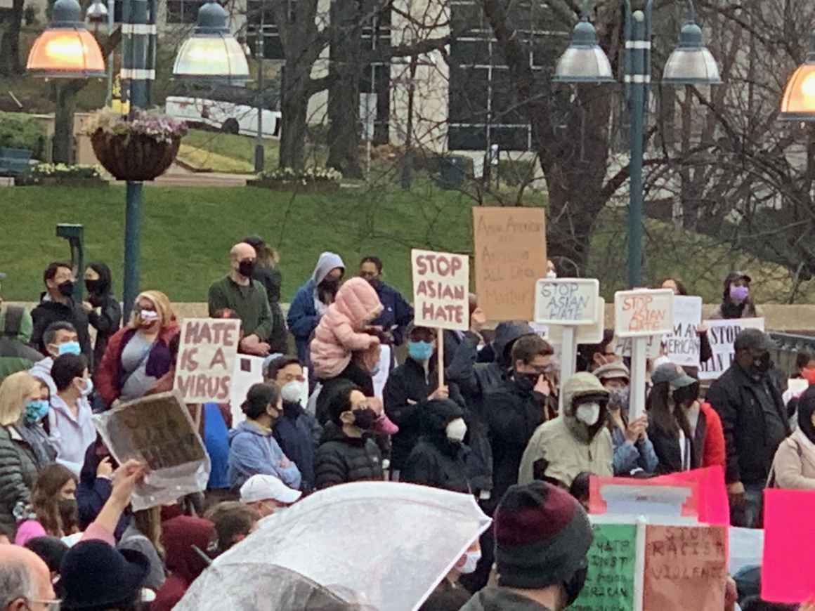 Rally attendees at the Stop Asian Hate rally in Columbia, Maryland. People are holding umbrellas and signs that say "Stop Asian Hate."