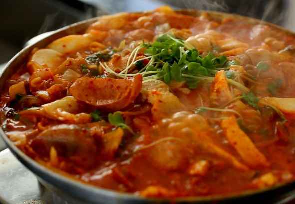 budae jjigae is a hot stew in a bowl, reddish in color. Picture from the Maangchi website.