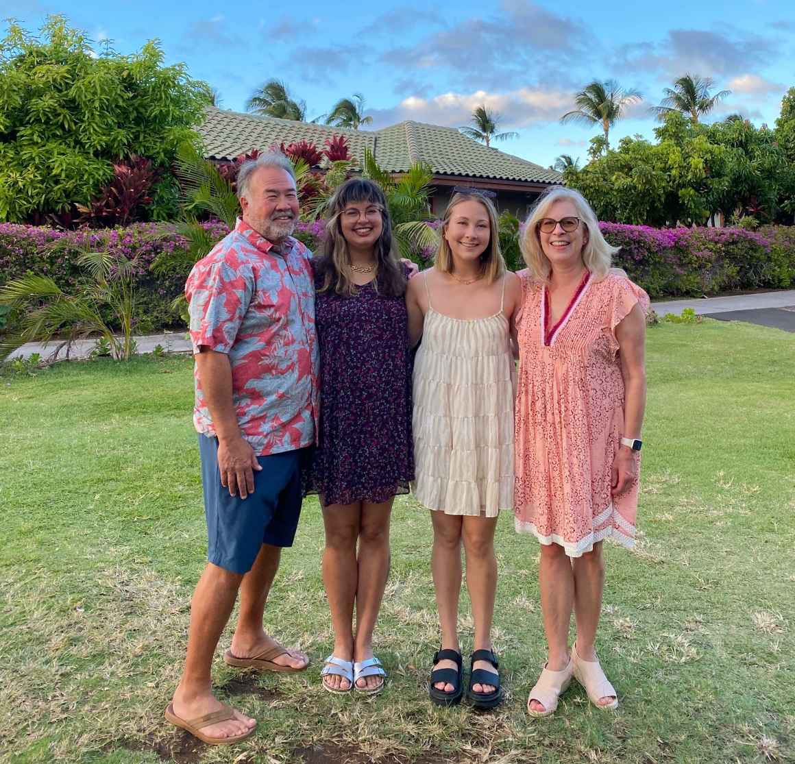 Olivia Spaccasi is standing with three family members. They are outside in Hawaii with trees, a house, and a blue sky behind them.