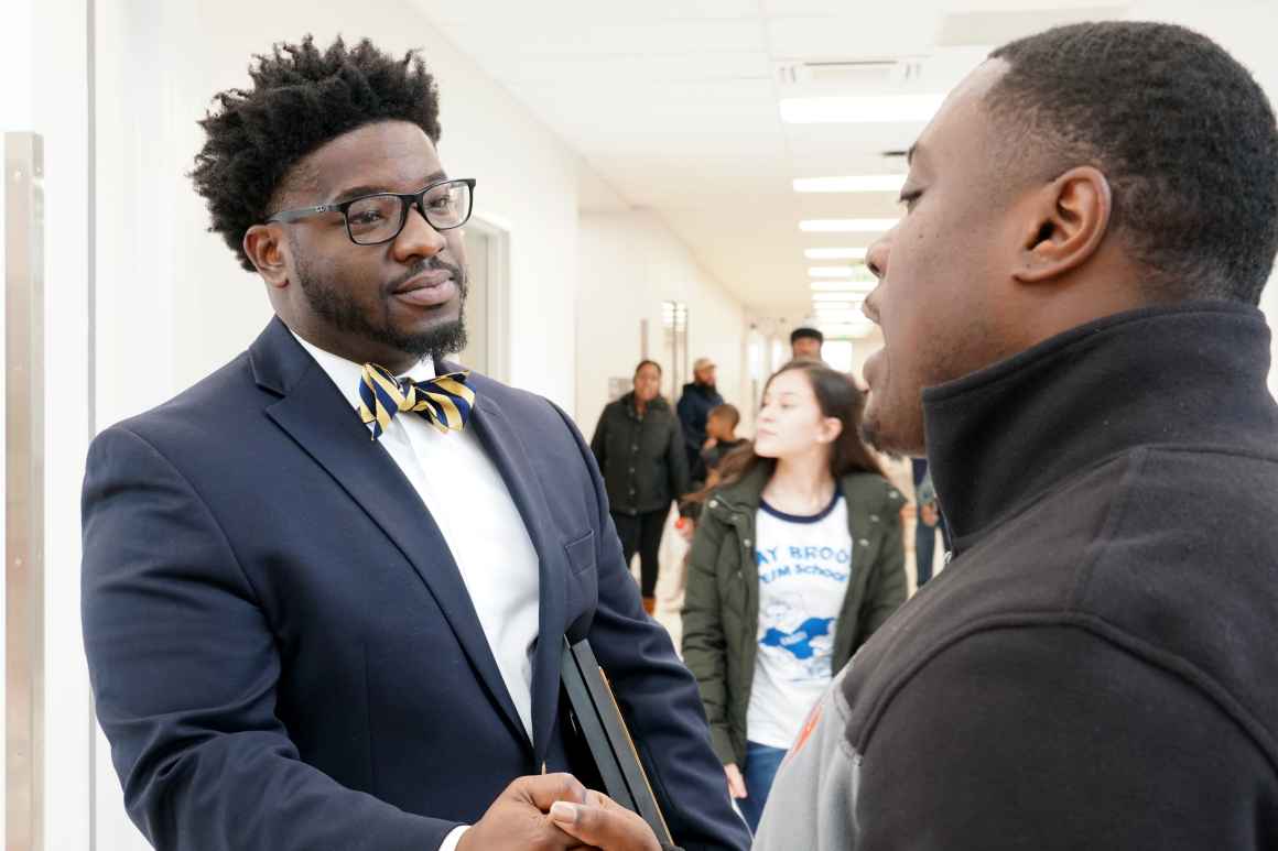 Samuel Rather II, the Principal at Calvin M. Rodwell Elementary/Middle, shakes hands with a parent.