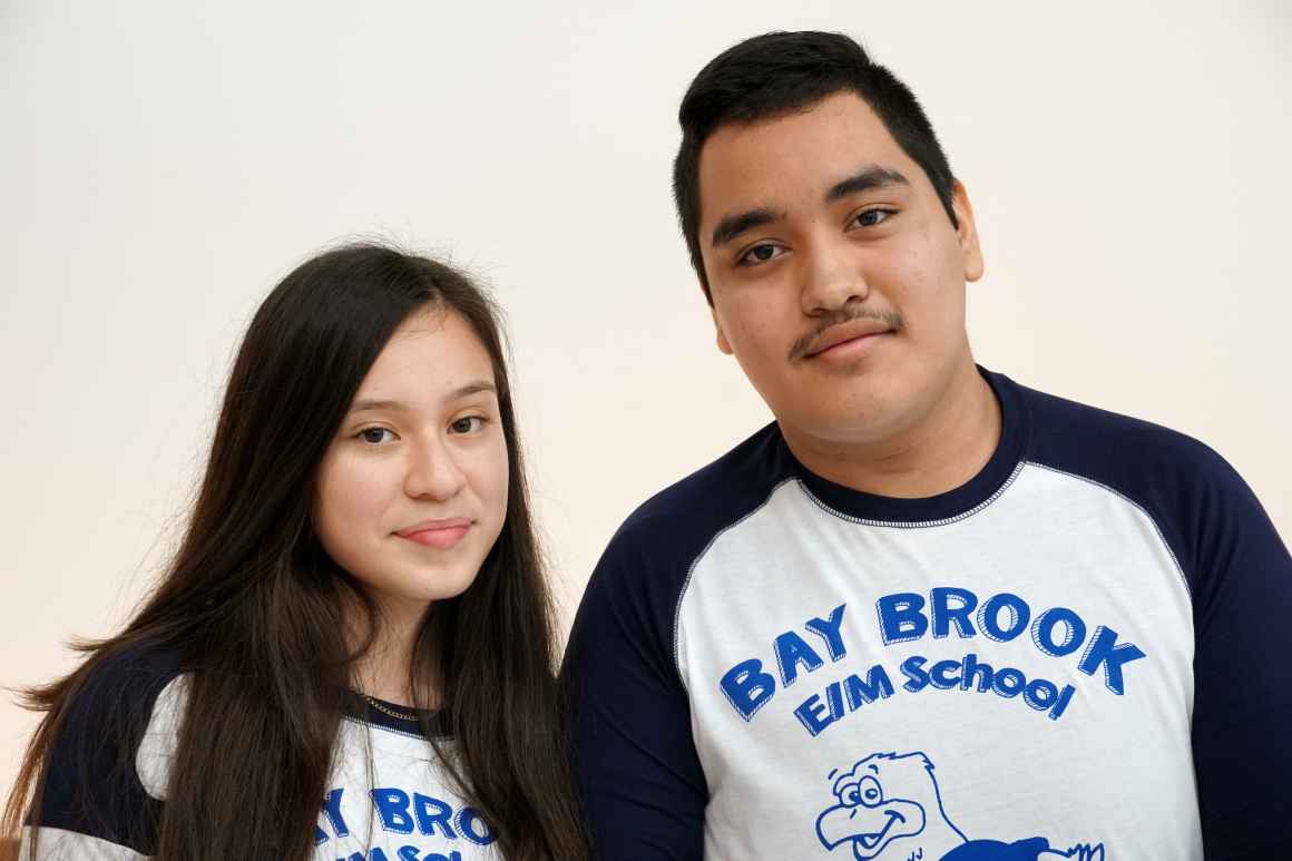 Tarsis Garcia (left) and Brandon Rivera (right) are Latinx students wearing shirts for their school Bay-Brook Elementary/Middle School. Tarsis has long dark brown hair and Brandon has short dark brown hair.