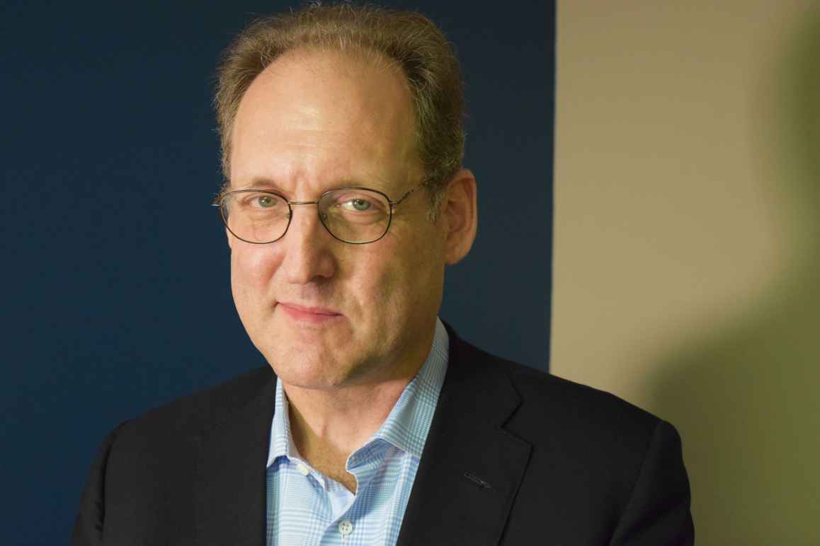 Coleman Bazelon, white man wearing glasses, black jacket, blue collared shirt