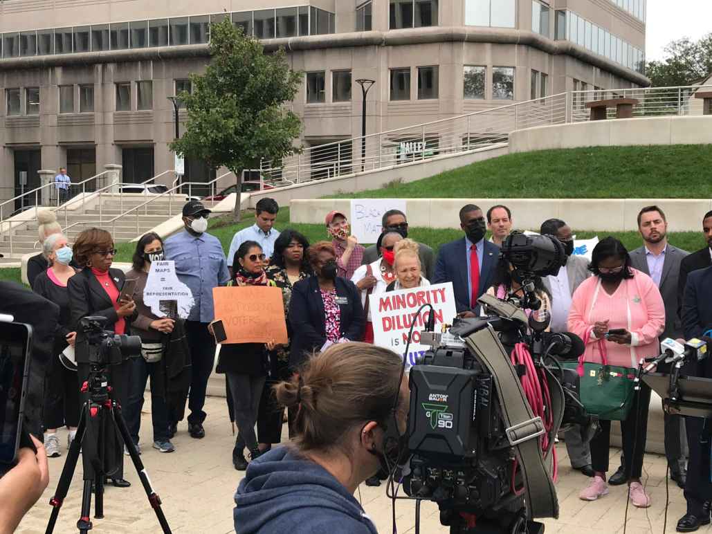 A group of activists stand outside together in Baltimore County at a press conference for the filing of a lawsuit to uphold the Voting Rights Act and create two majority-Black districts.