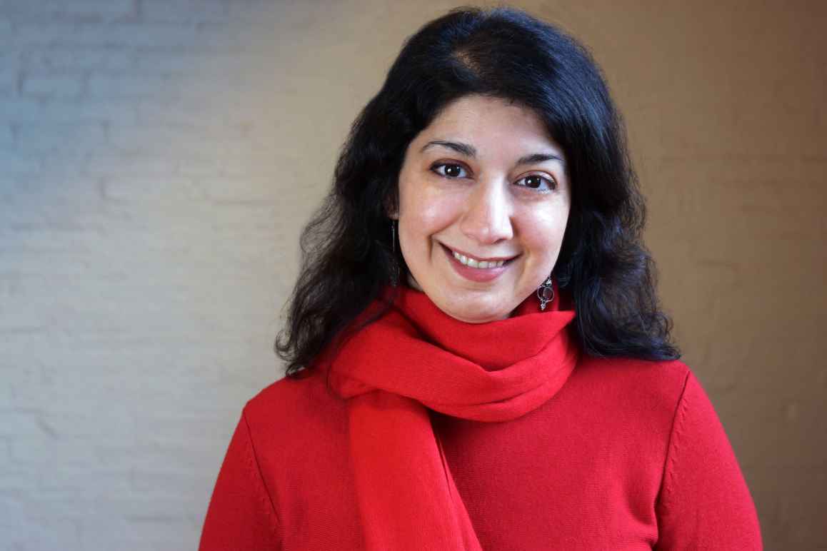 Homayra Ziad, woman with dark, medium-lenth hair, wearing a red shirt and scarf