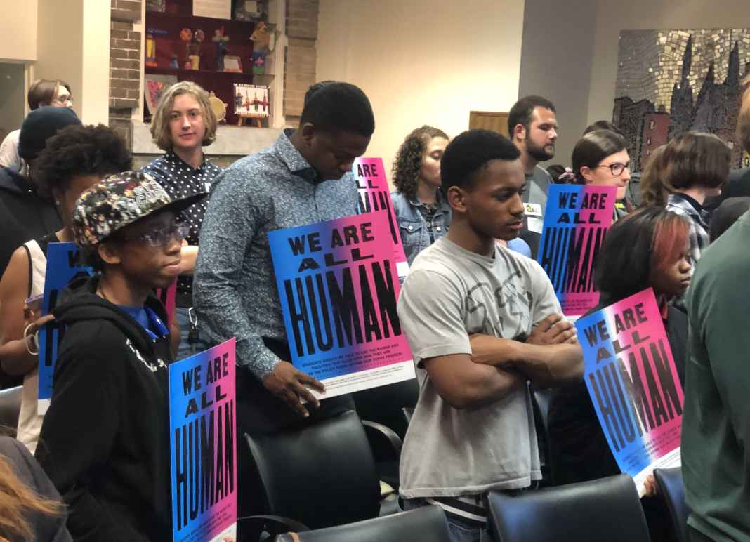 We are all human - students at school board meeting holding posters