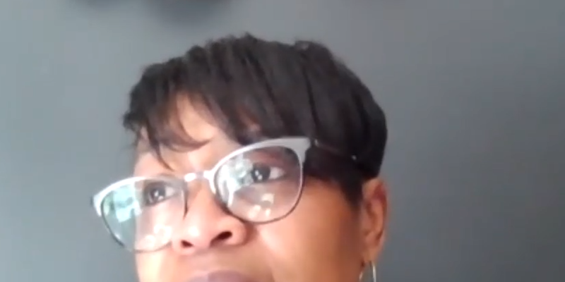 Josette Blocker is a Black woman with short hair swooped to the side. She is wearing cat-eye glasses and is looking toward the upper left of the screen.