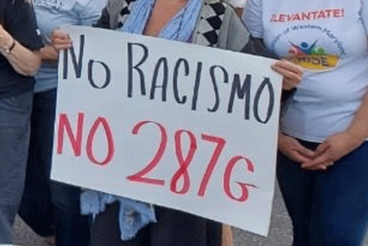 People hands shown holding a protest sign that says, "No Racismo, no 287g."