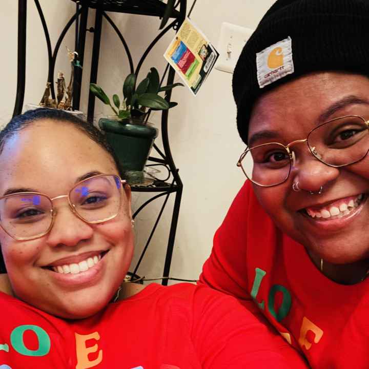 Antoinette and Alicia celebrating with family on Christmas 2023. They are wearing matching red holiday outfits.They were celebrating with family on Christmas 2023.